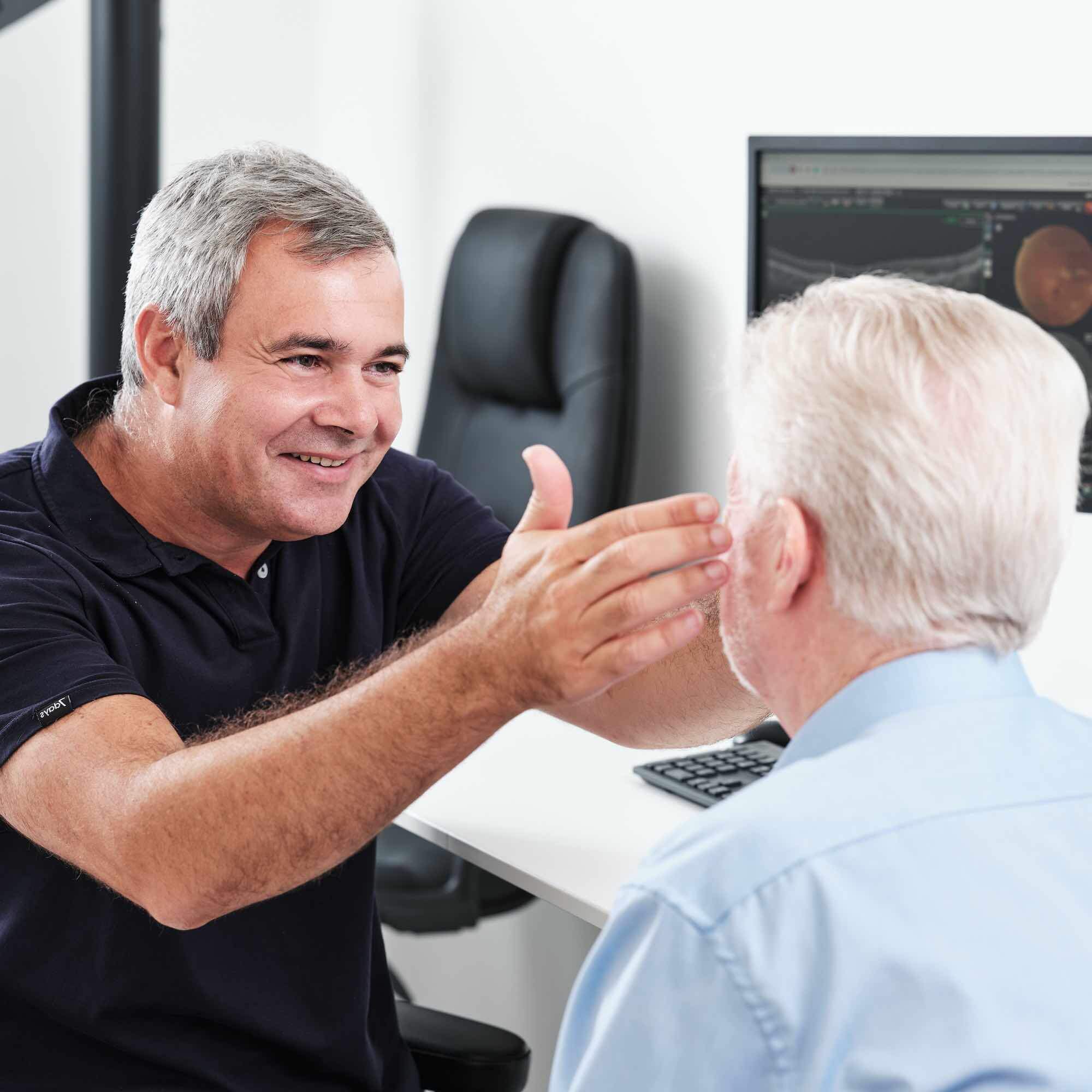 På billedet ses en øjenlæge, som undersøger en patient for flydere.