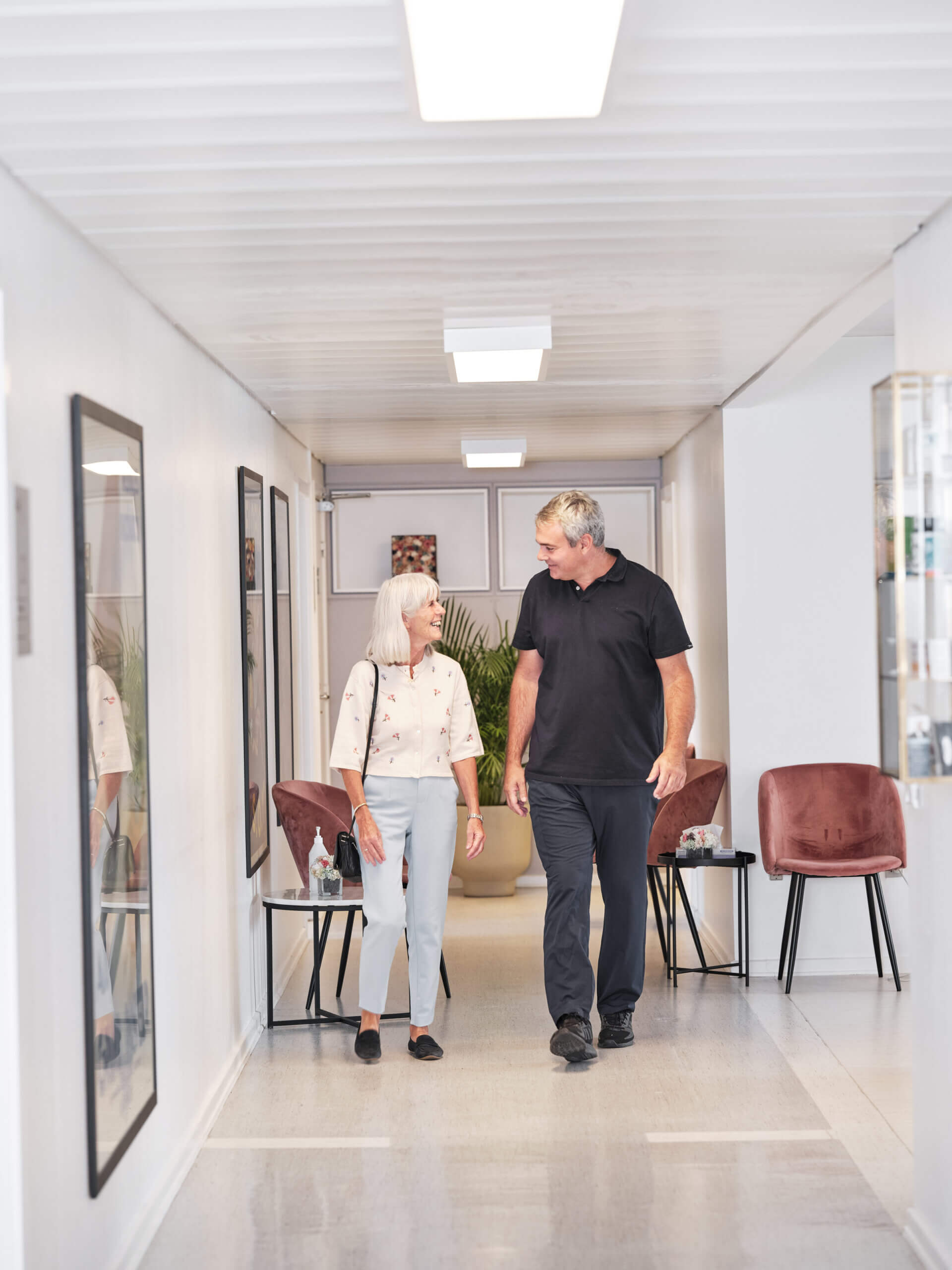 Øjenlæge, Johan, følger en AMD patient ned ad gangen.