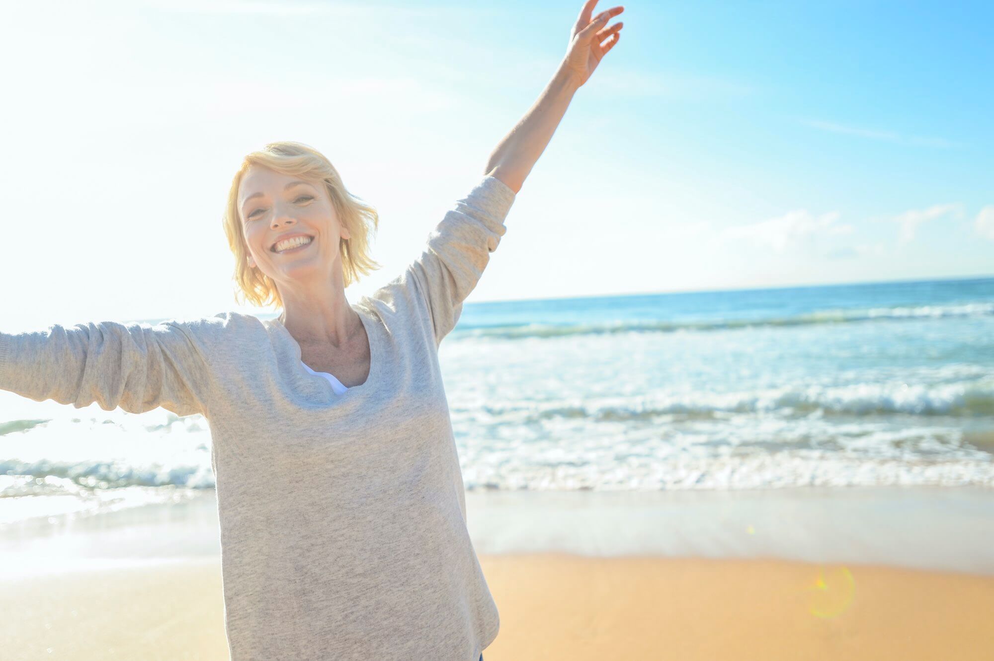 En dame føler frihed på stranden uden brug af briller.