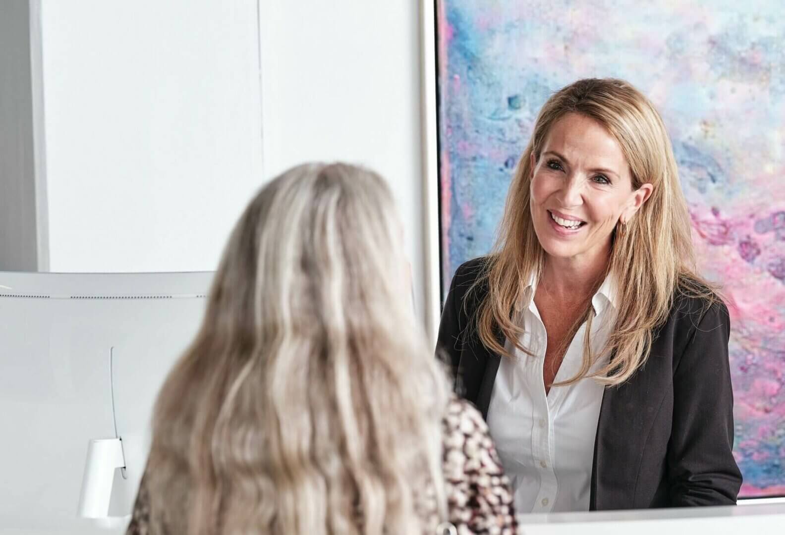 Patientkoordinator Silje hjælper en patient i receptionen.