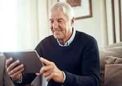 Nærafstand syn - læseafstand med tablet ipad. En mand sidder og læser en bog.