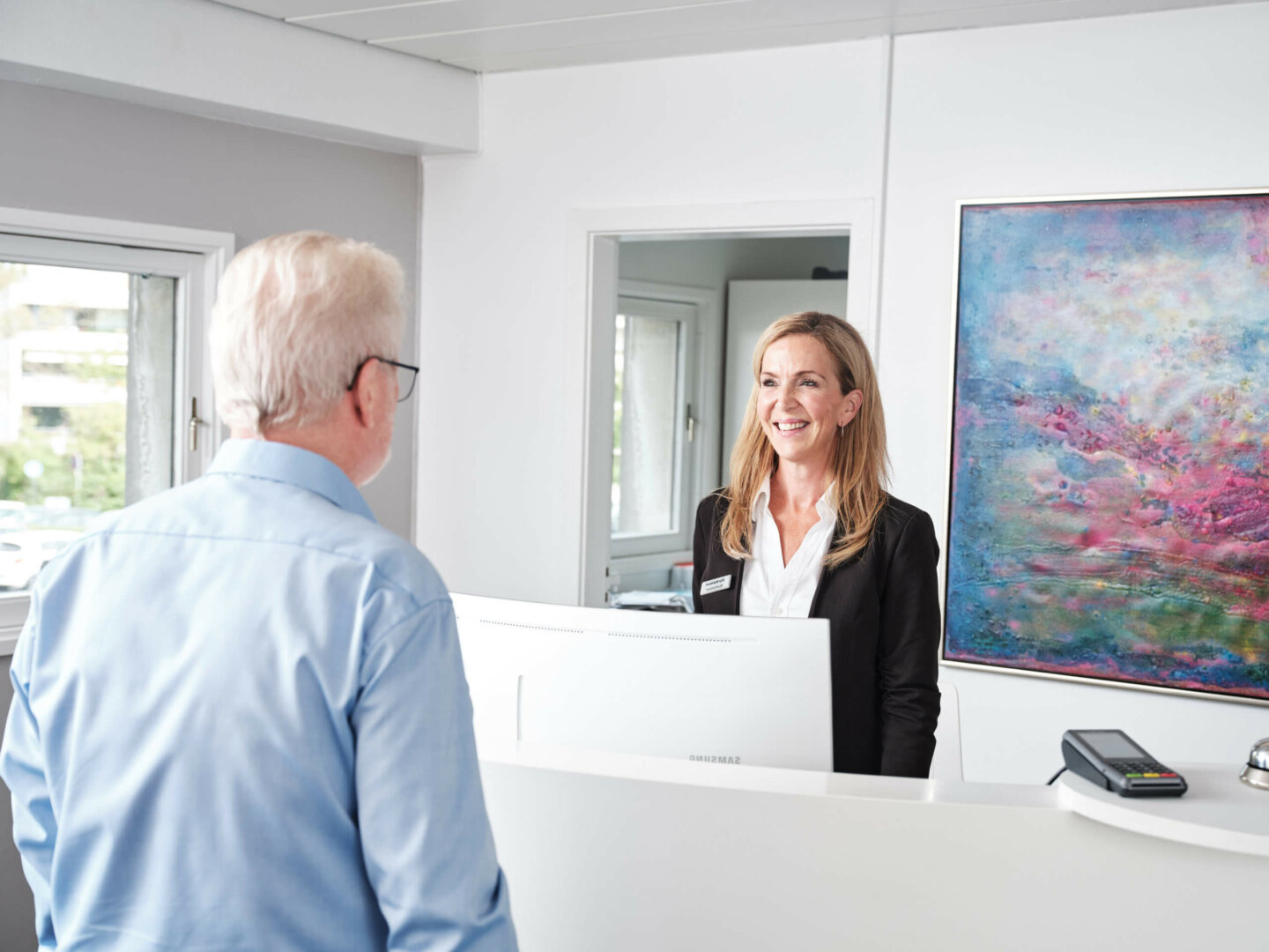 Servicepersonale fra Øjenhospitalet Danmark oplyser en patient om priser.